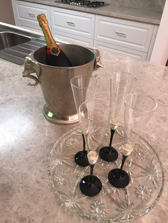 Four champagne flutes on a tray next to a bucket