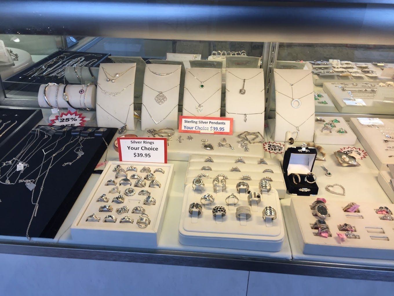 a display case filled with lots of jewelry including necklaces and rings