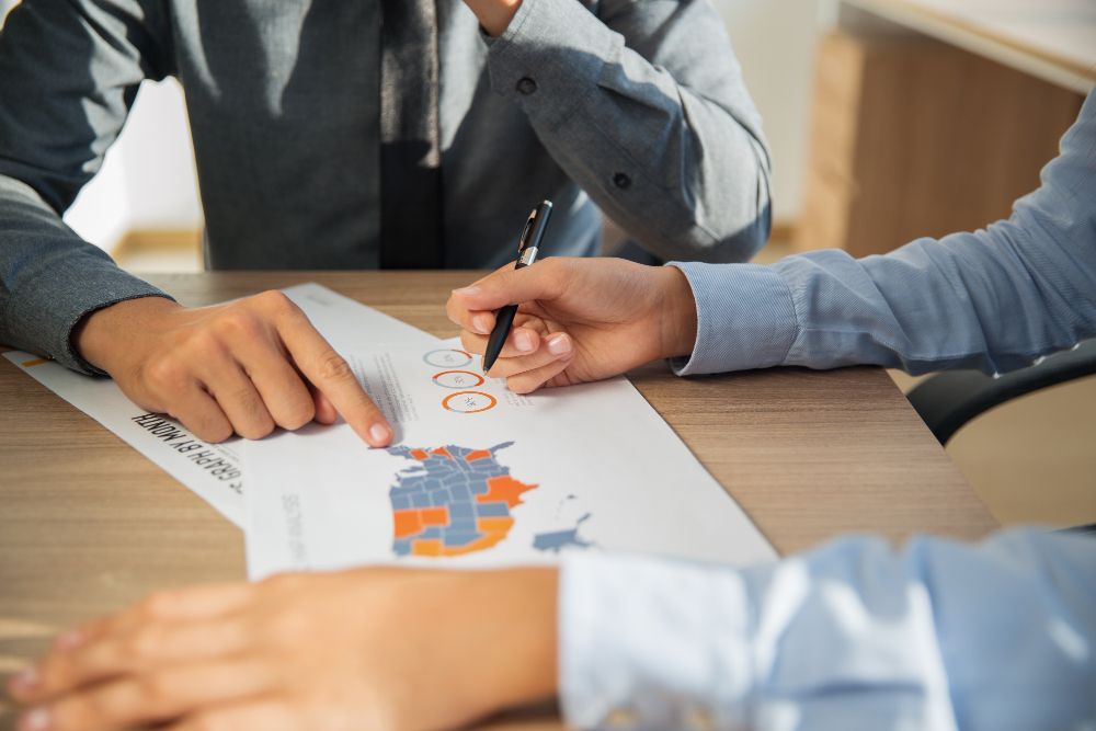 Two people are sitting at a table looking at a piece of paper.