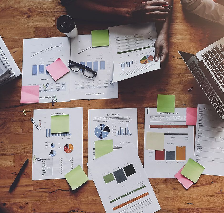 A person is sitting at a table with papers and a laptop.