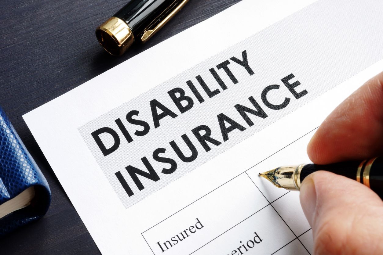 A person is filling out a disability insurance form