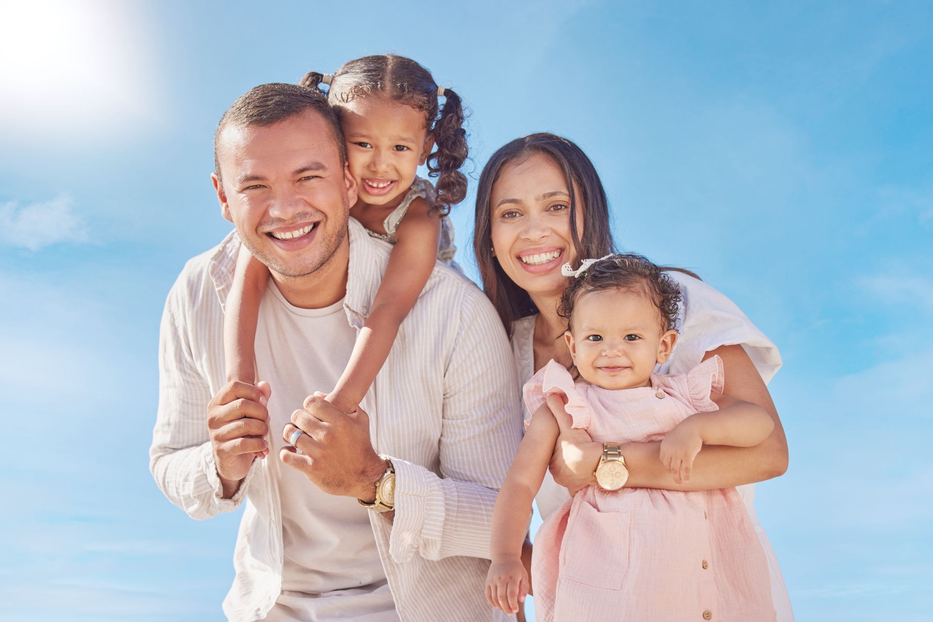 A family is posing for a picture on the beach.