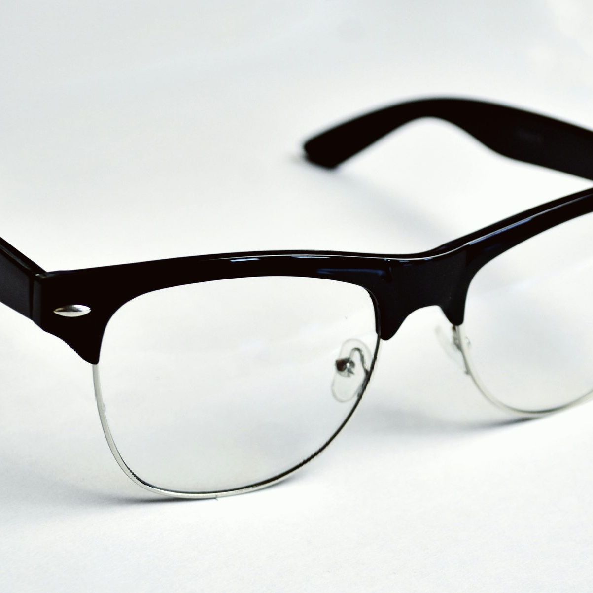 A pair of glasses with clear lenses on a white surface