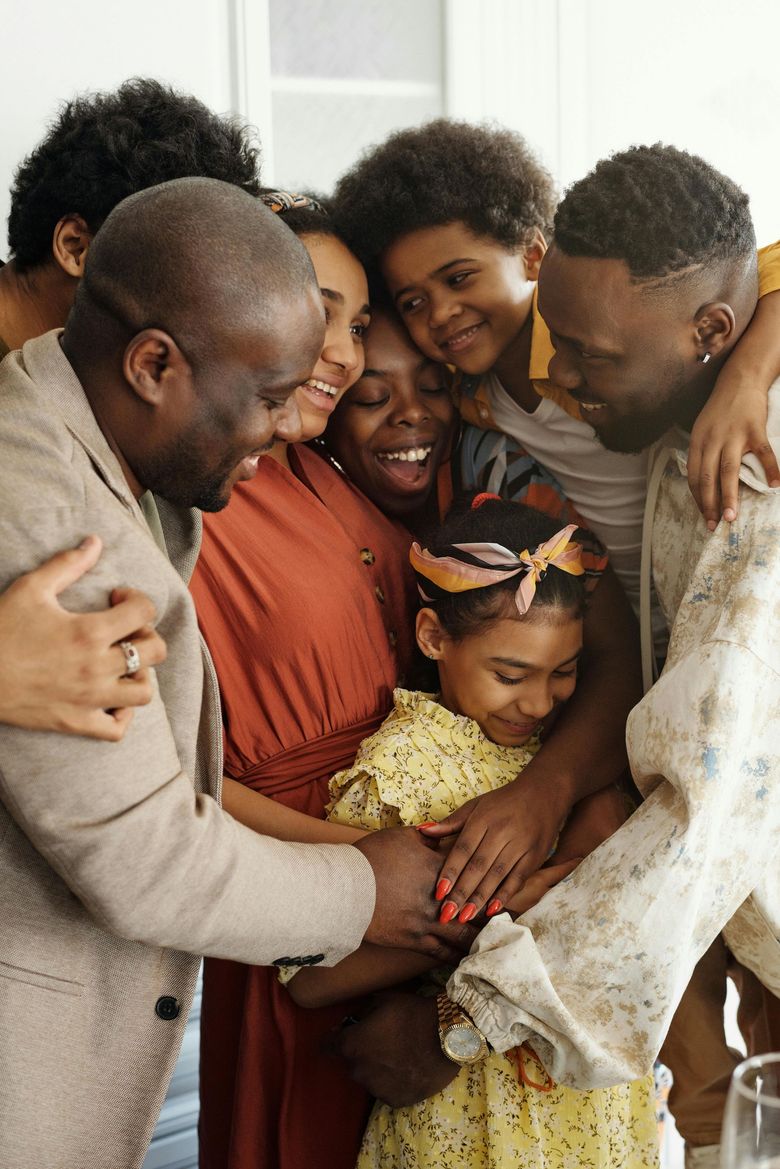 A family is sitting on the floor with a piggy bank.