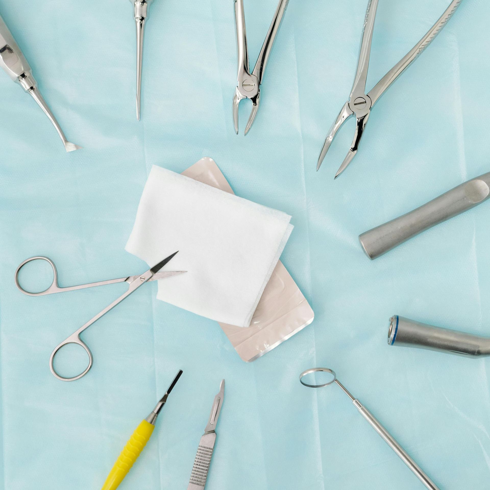 A bunch of dental instruments on a blue cloth