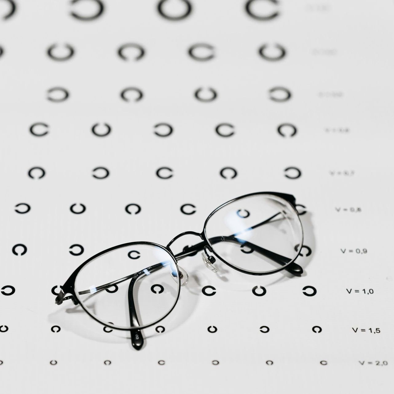 A pair of glasses sitting on top of an eye chart