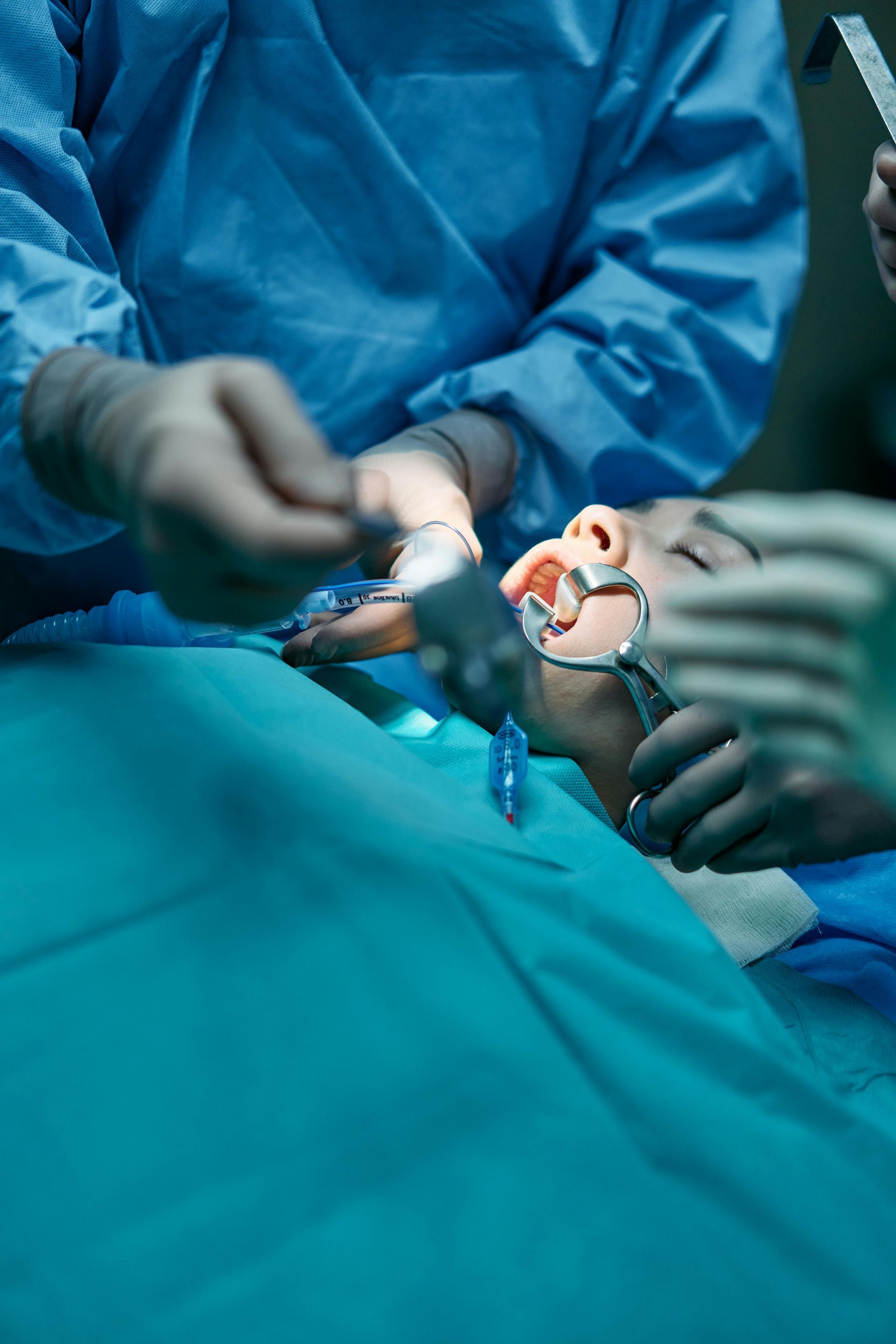 A surgeon is operating on a patient in an operating room.