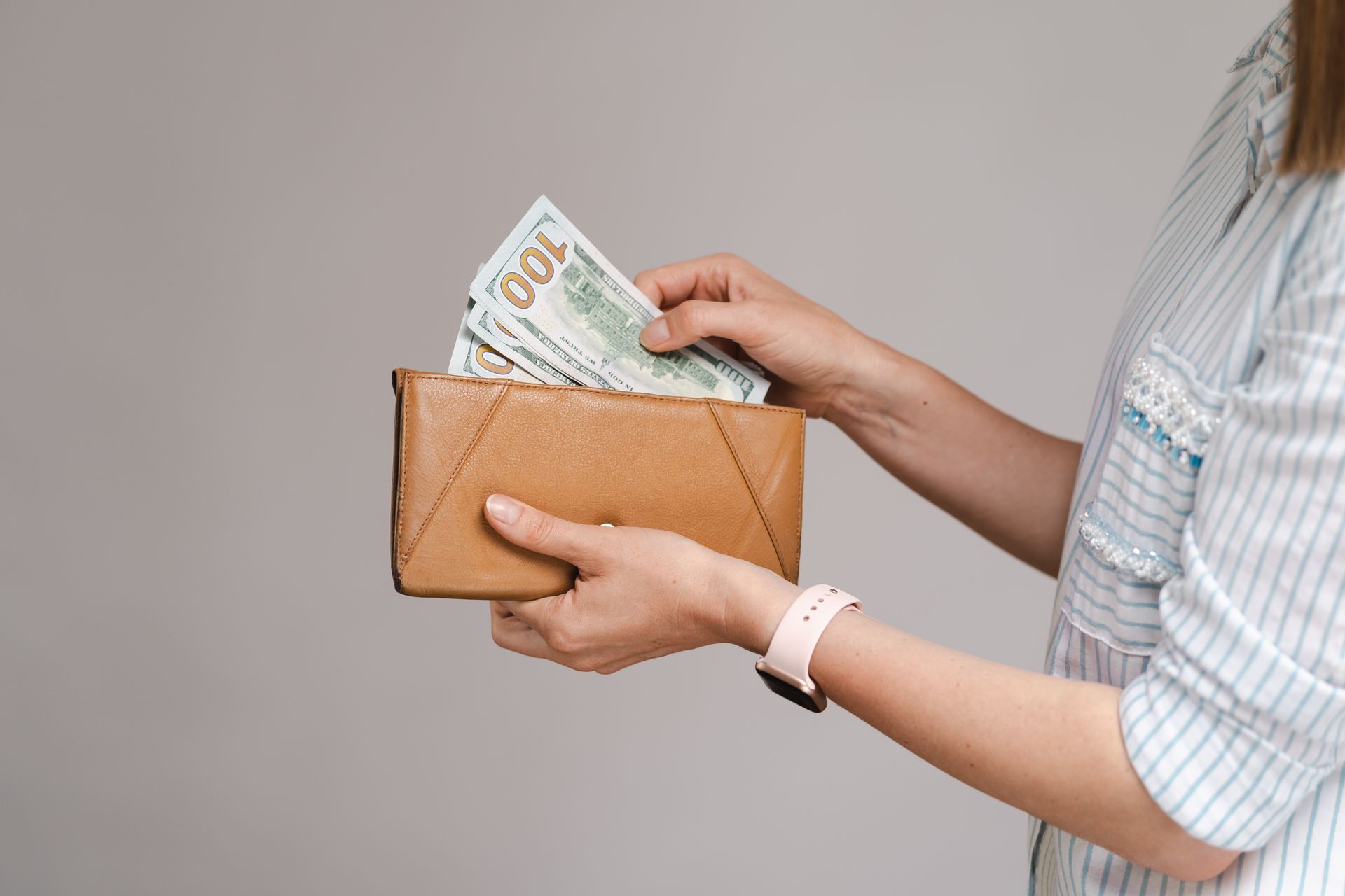 A woman is taking money out of her wallet.