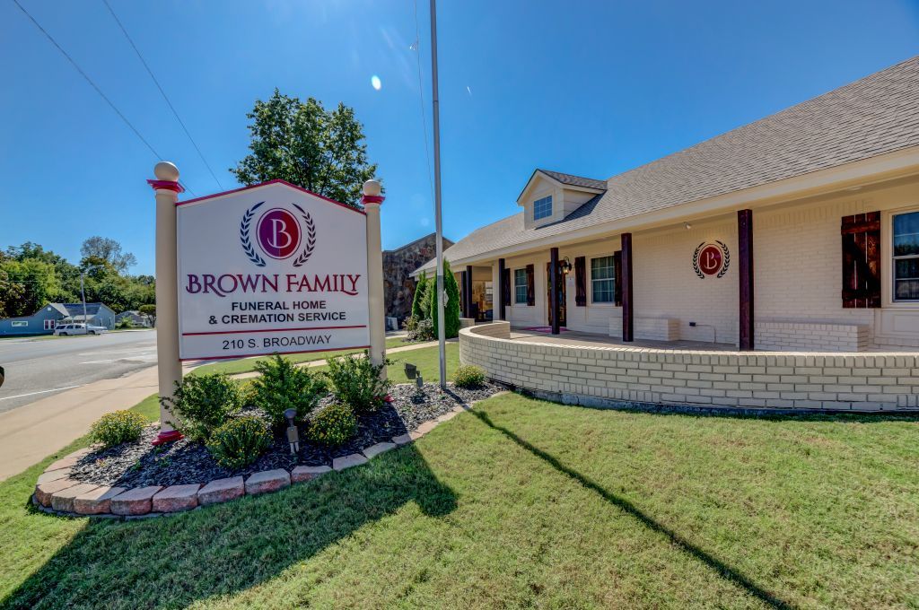 A white building with a sign in front of it that says brown family.
