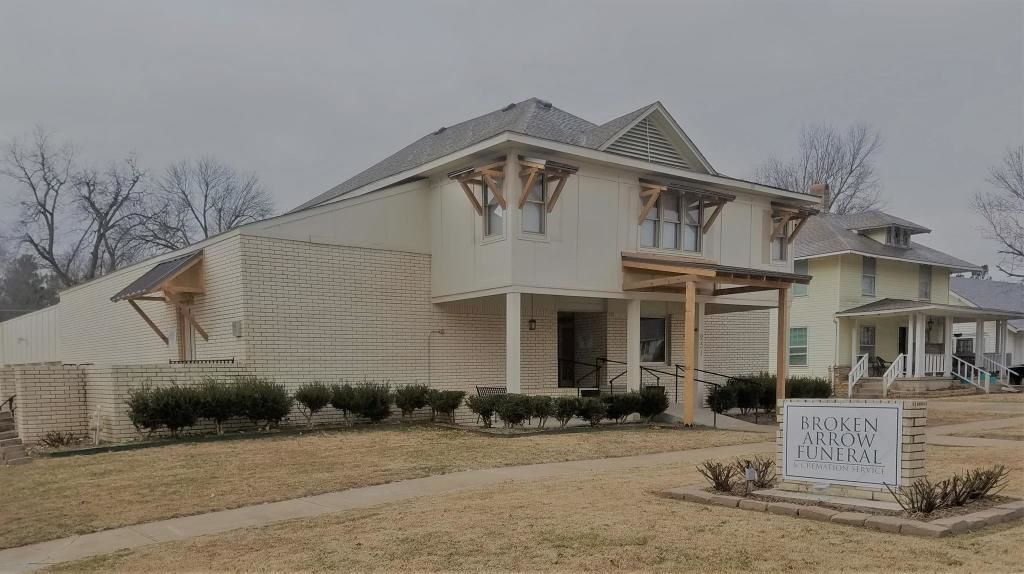 A white house with a sign in front of it that says Broken Arrow Funeral