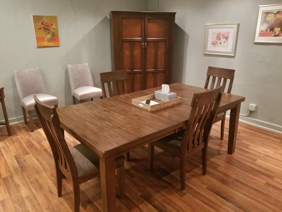 A dining room with a wooden table and chairs