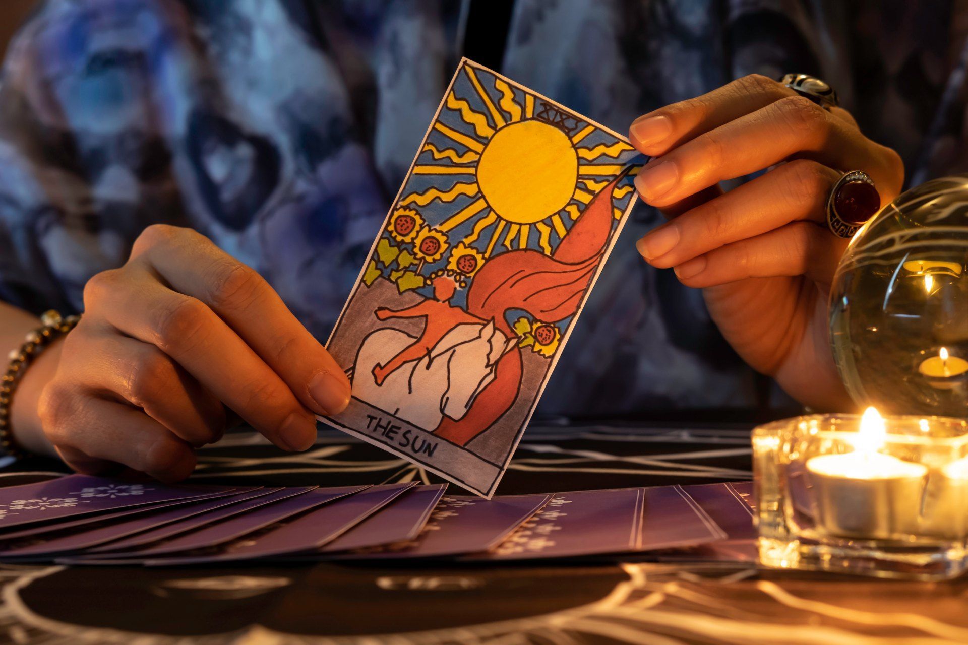 A person is holding a tarot card in their hands.