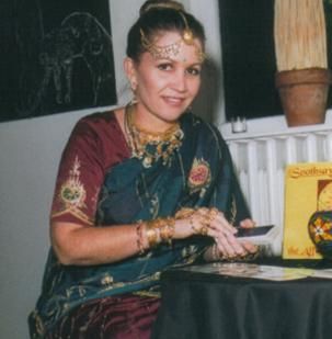 A woman is sitting at a table in front of a sign that says southern