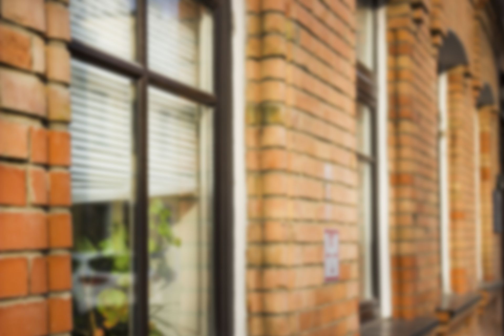 Blurry brick building with windows and reflections.