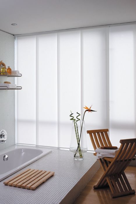 Brown woven window shades, partially closed, allowing sunlight to filter through.