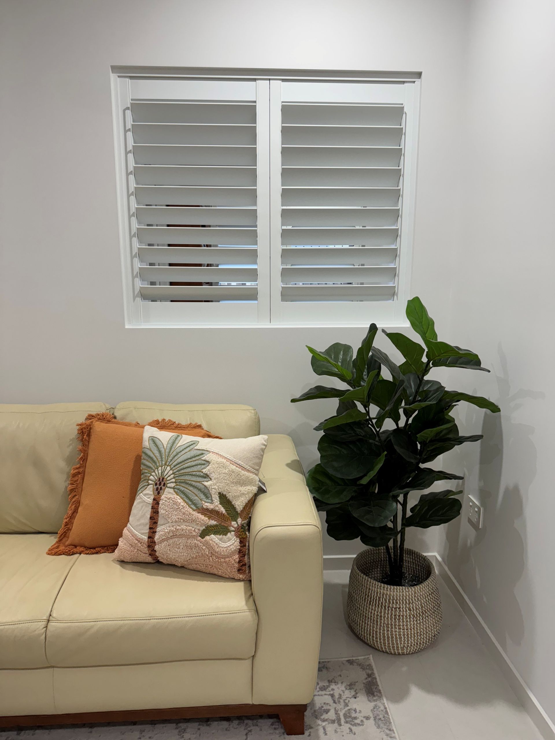 Display of various window blinds, featuring different styles, colors, and textures, arranged in a grid within a store or showroom.