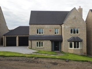 A large brick house with a black roof and white windows