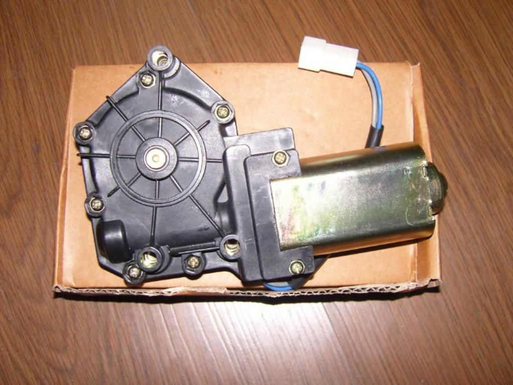 A motor is sitting in a cardboard box on a wooden table