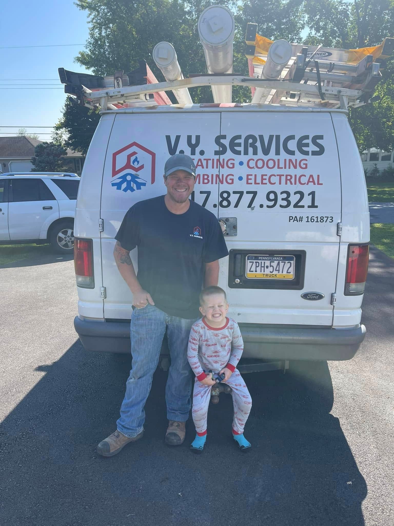 A man and a child are standing in front of a van.