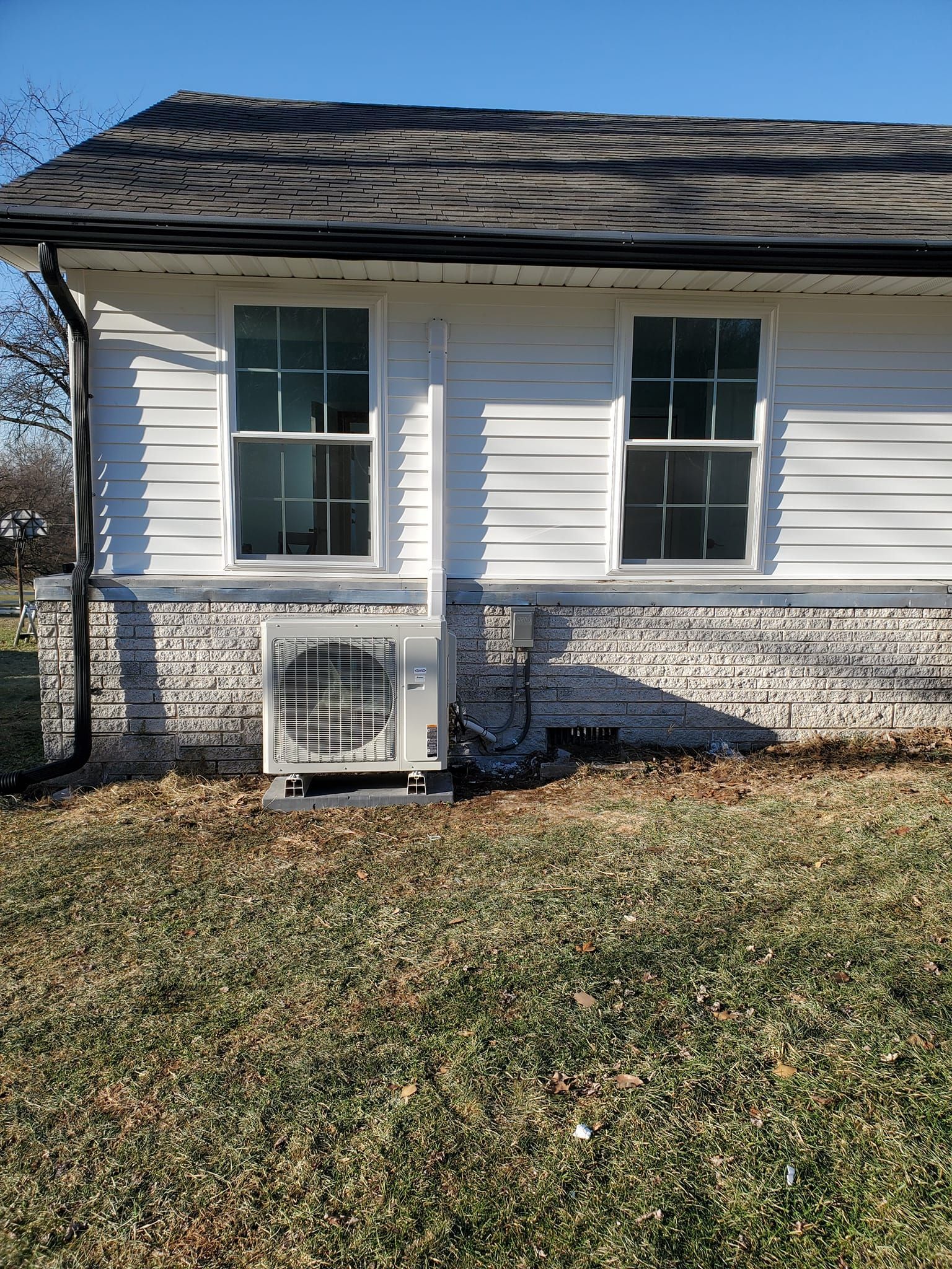 A white house with a window and a fan on the side of it.