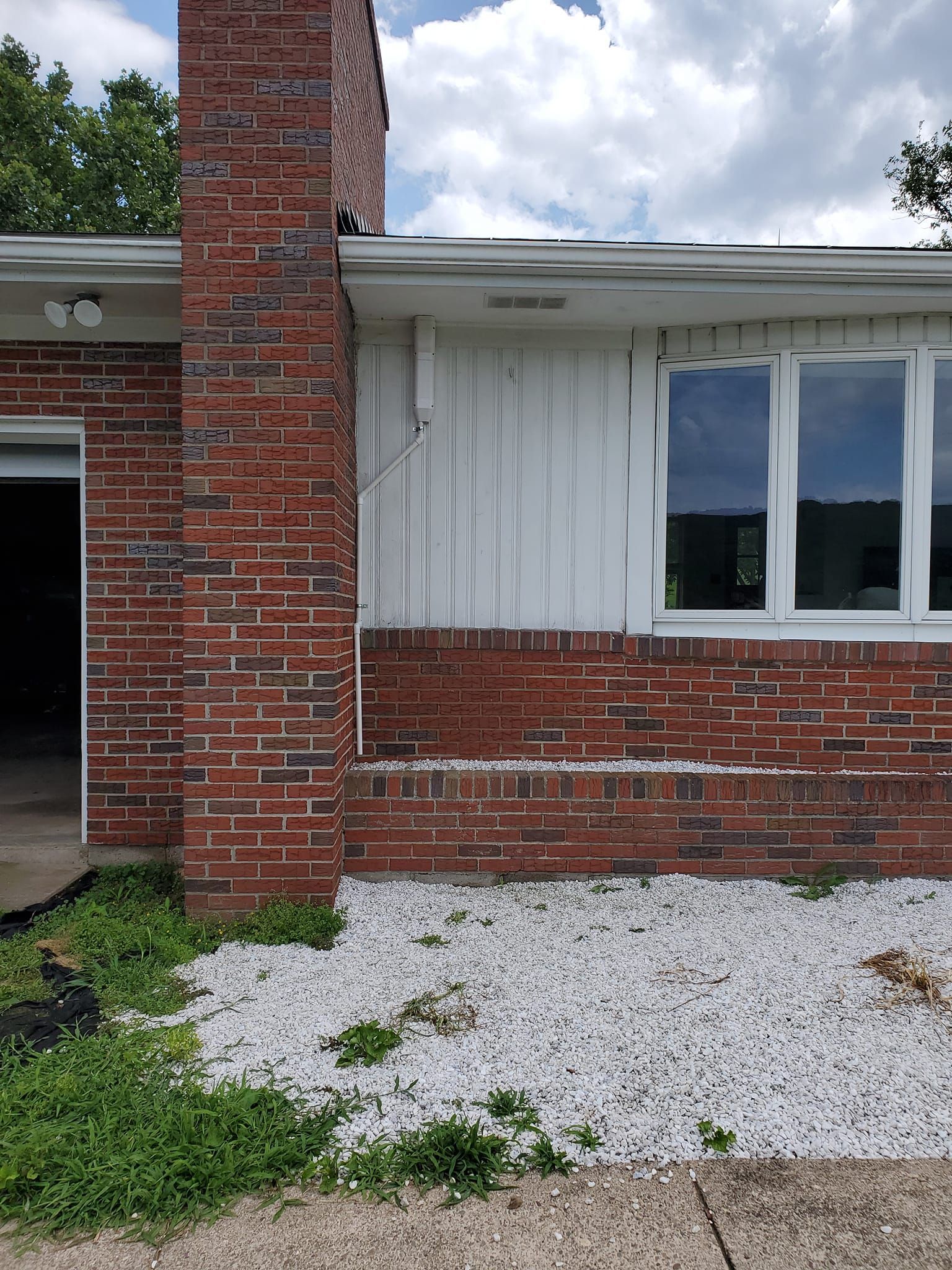 A brick house with a white trim and a chimney.