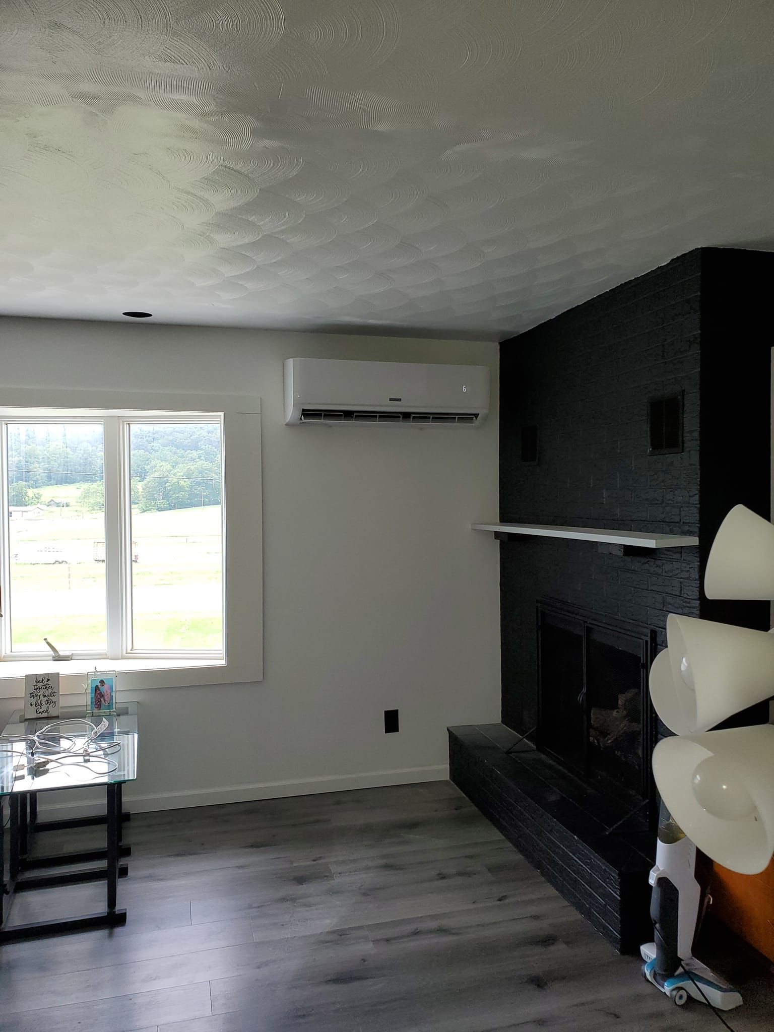 A living room with a fireplace and a window.