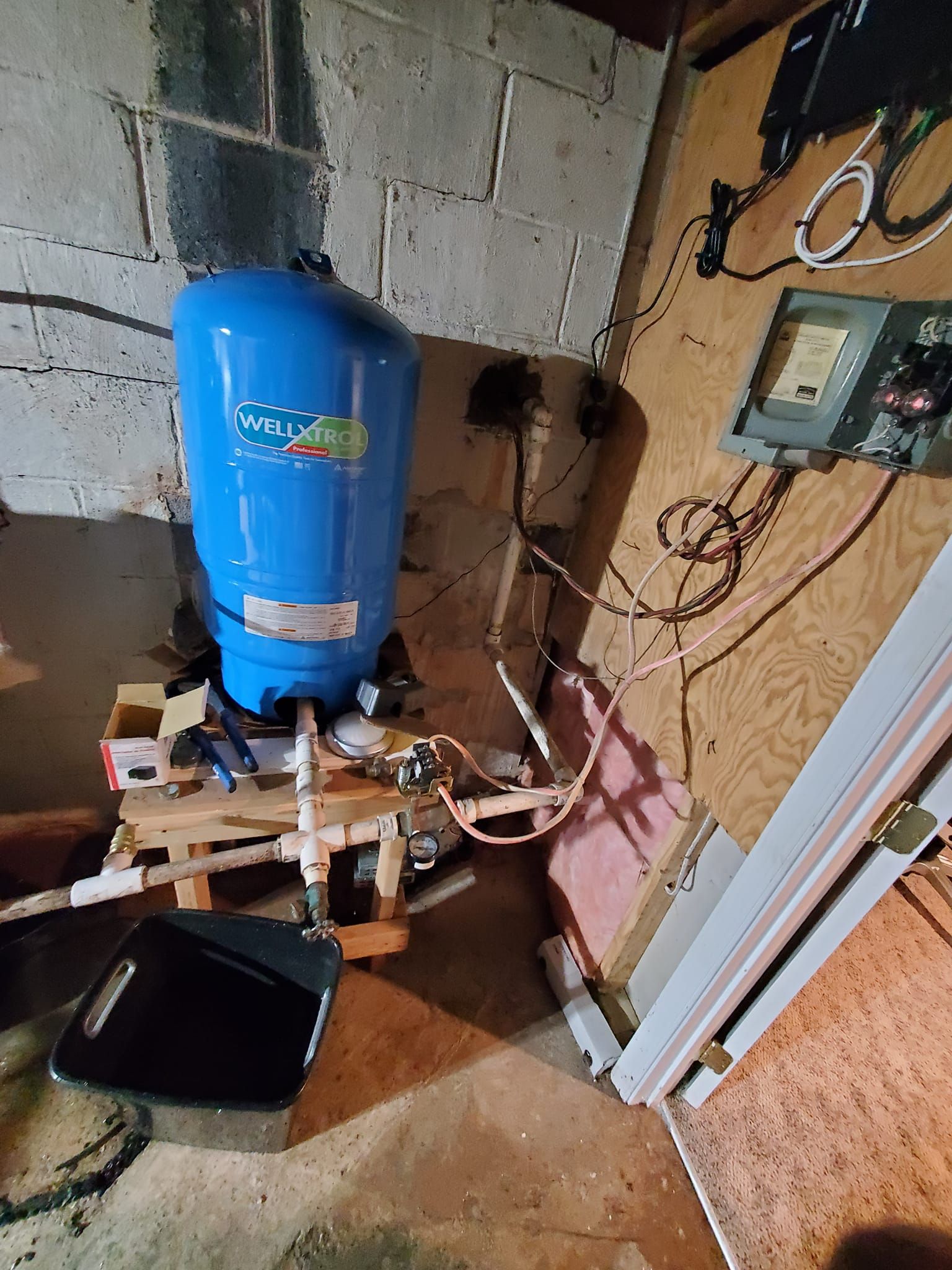 A blue water tank is sitting on top of a wooden table in a room.