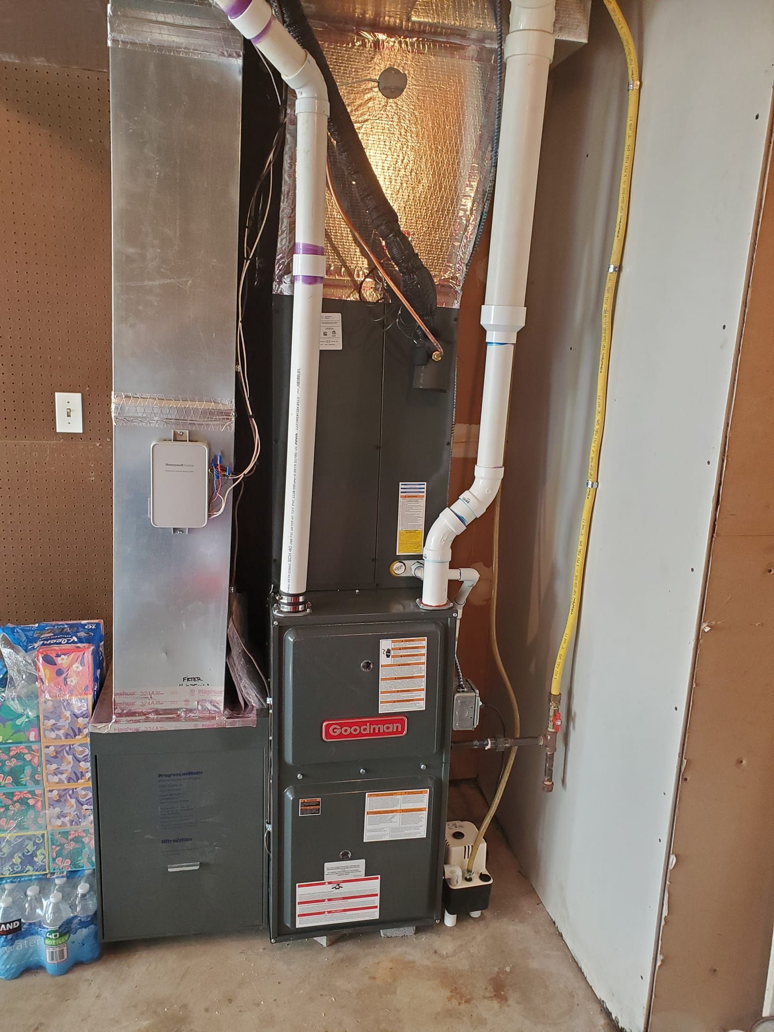 A furnace is sitting in a room next to a wall.