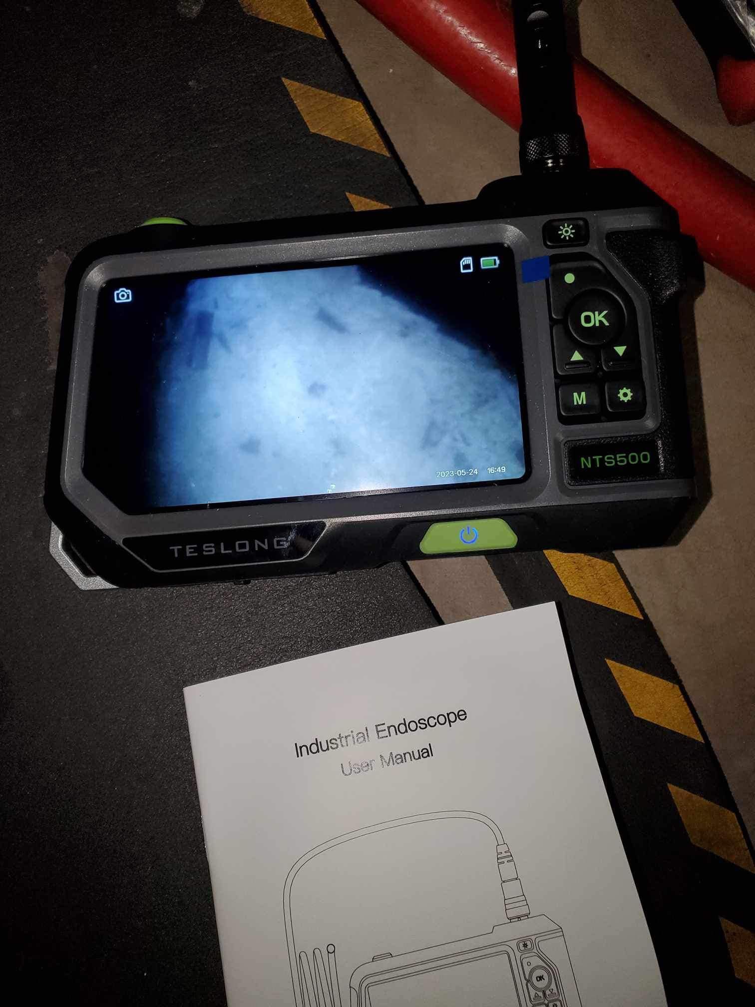 A camera is sitting on a table next to a manual.