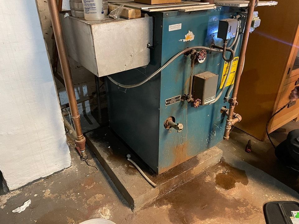 A blue boiler is sitting on the floor in a room.