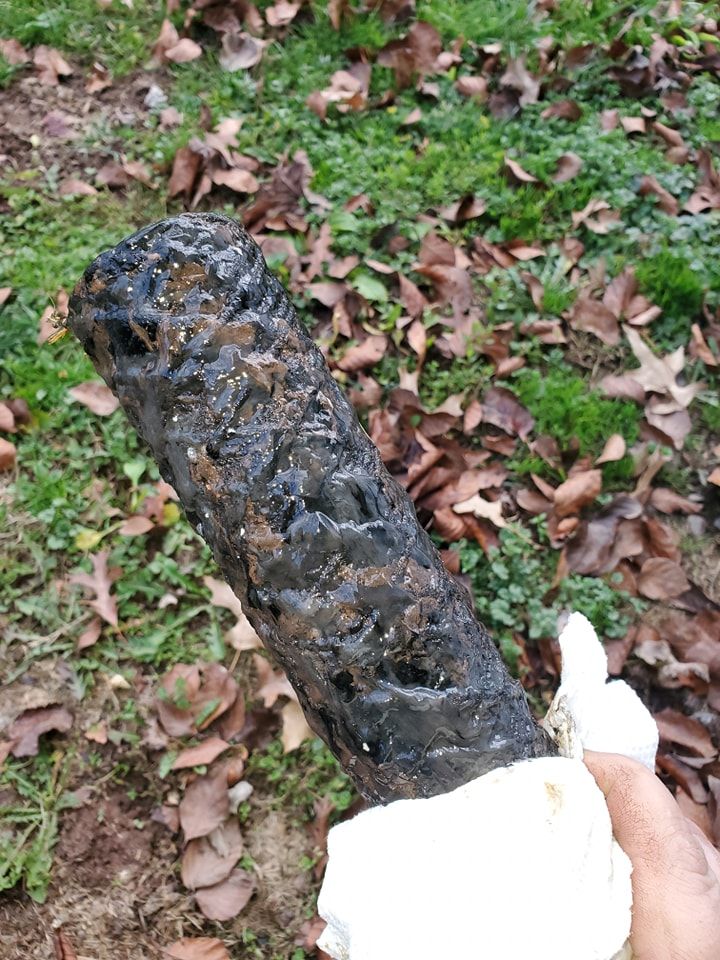 A person is holding a piece of wood in their hand.