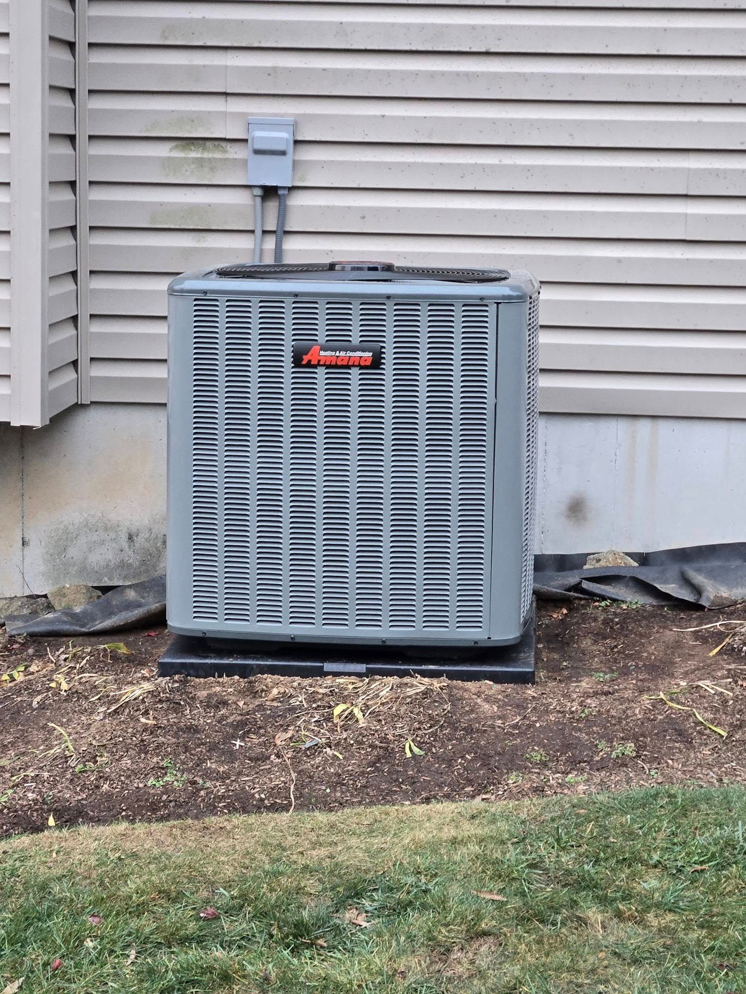 An air conditioner is sitting on the side of a house.