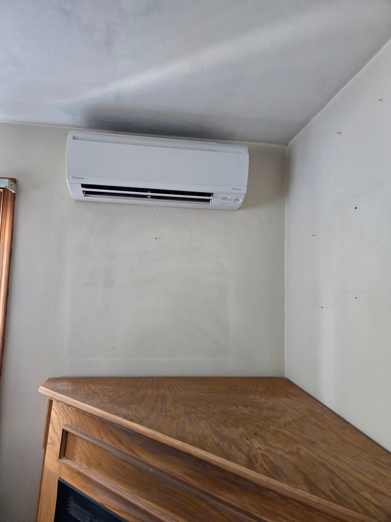 A room with a fireplace and a wall mounted air conditioner.