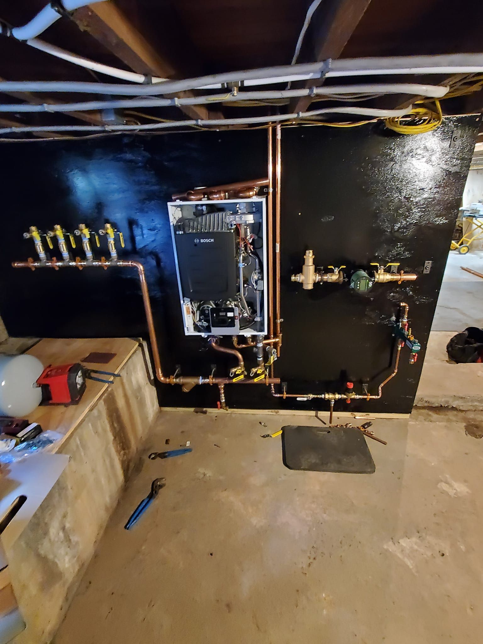 A water heater is being installed in a basement.