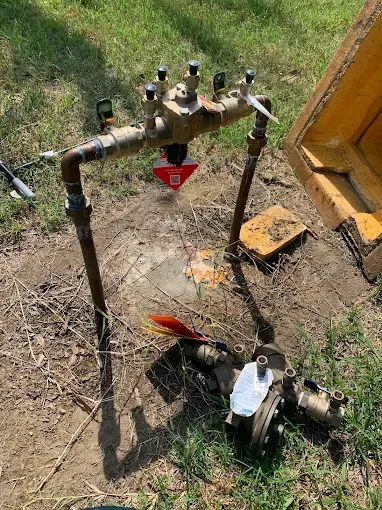 Backflow preventer irrigation system, brass and copper pipes in a yard.