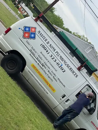 White van with "Master & Sons Plumbing Services" logo; worker in driver's seat.