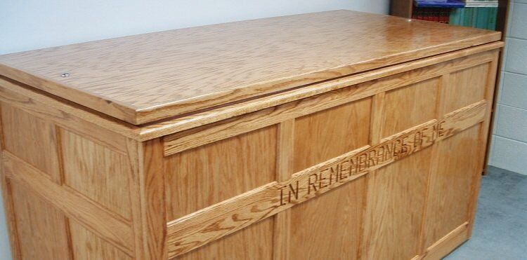 A wooden box with a cork top is sitting on a concrete floor.