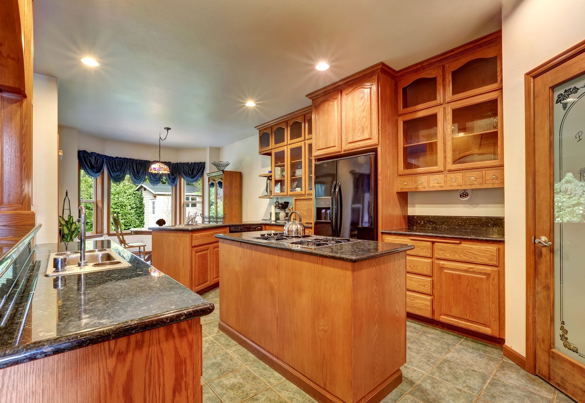 Kitchen with wooden cabinets, granite countertops, and two islands.