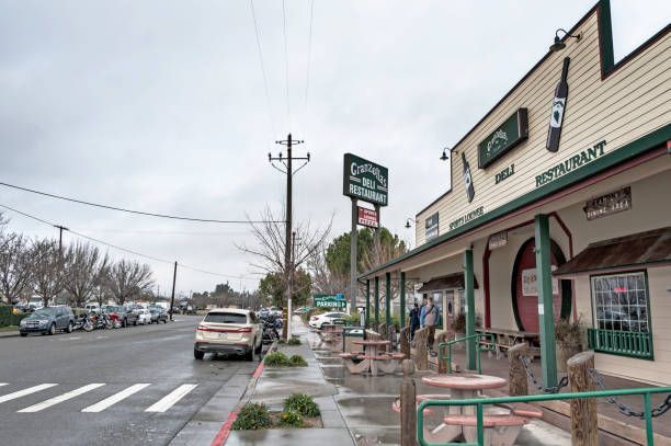 A car is parked on the side of the road in front of a restaurant.