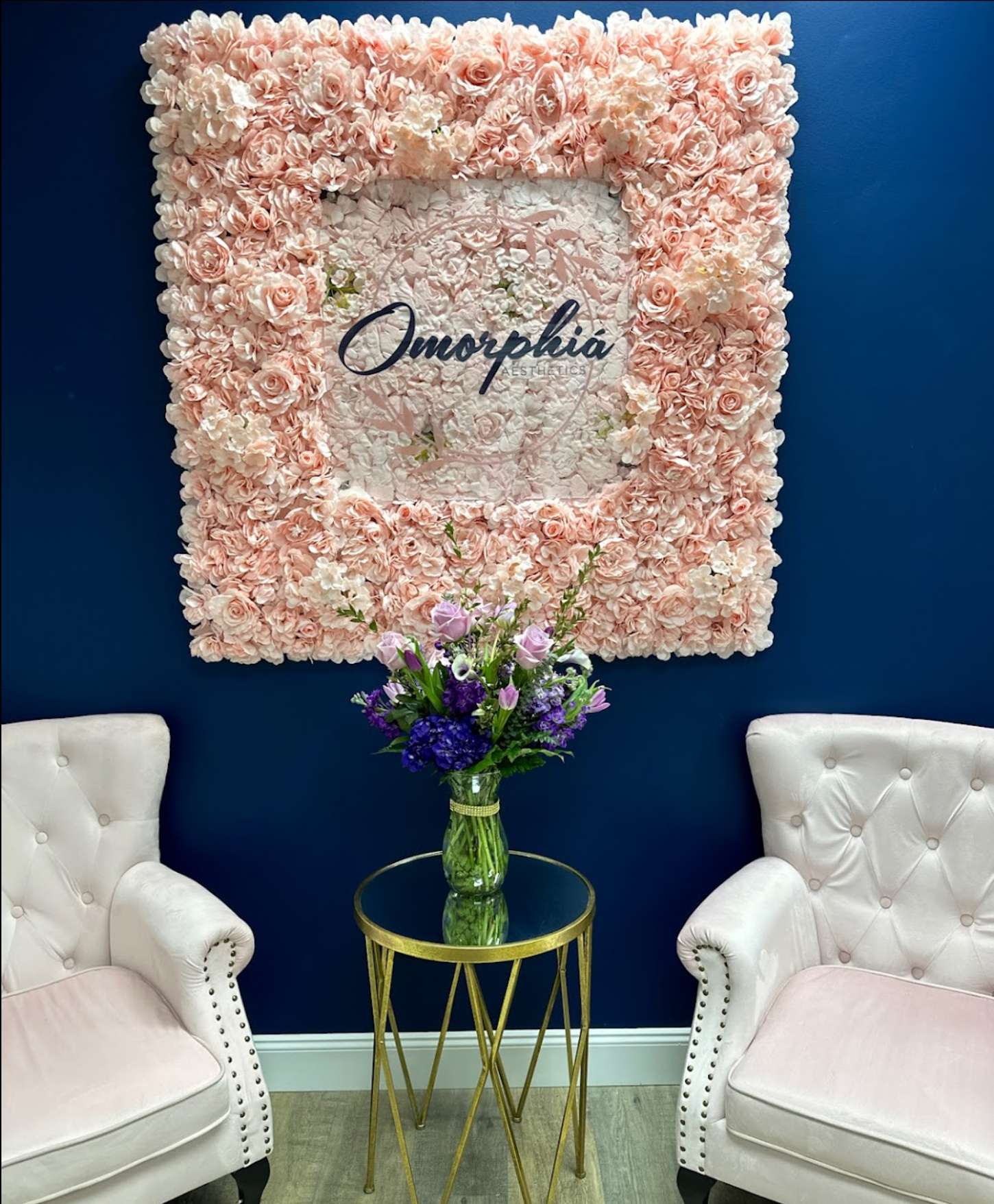 A room with two chairs and a table with flowers on it.