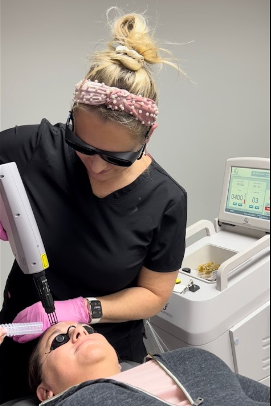 A woman is getting a laser treatment on her face.