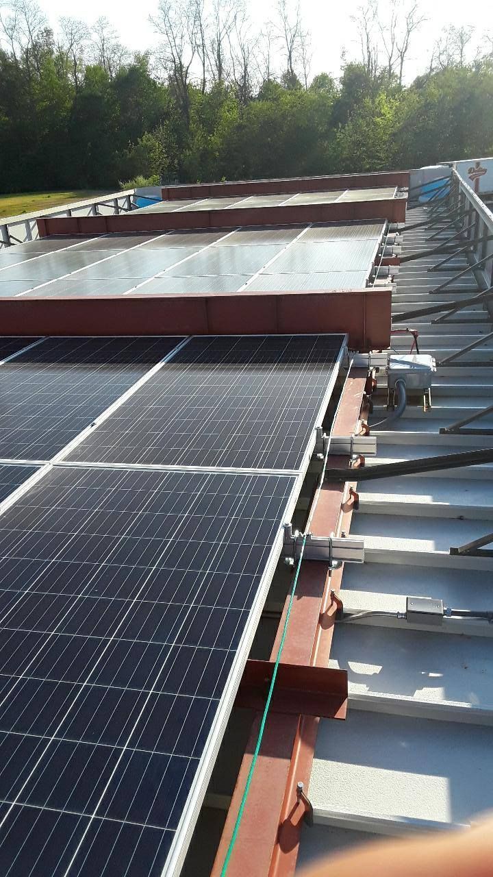 A row of solar panels on the roof of a building.