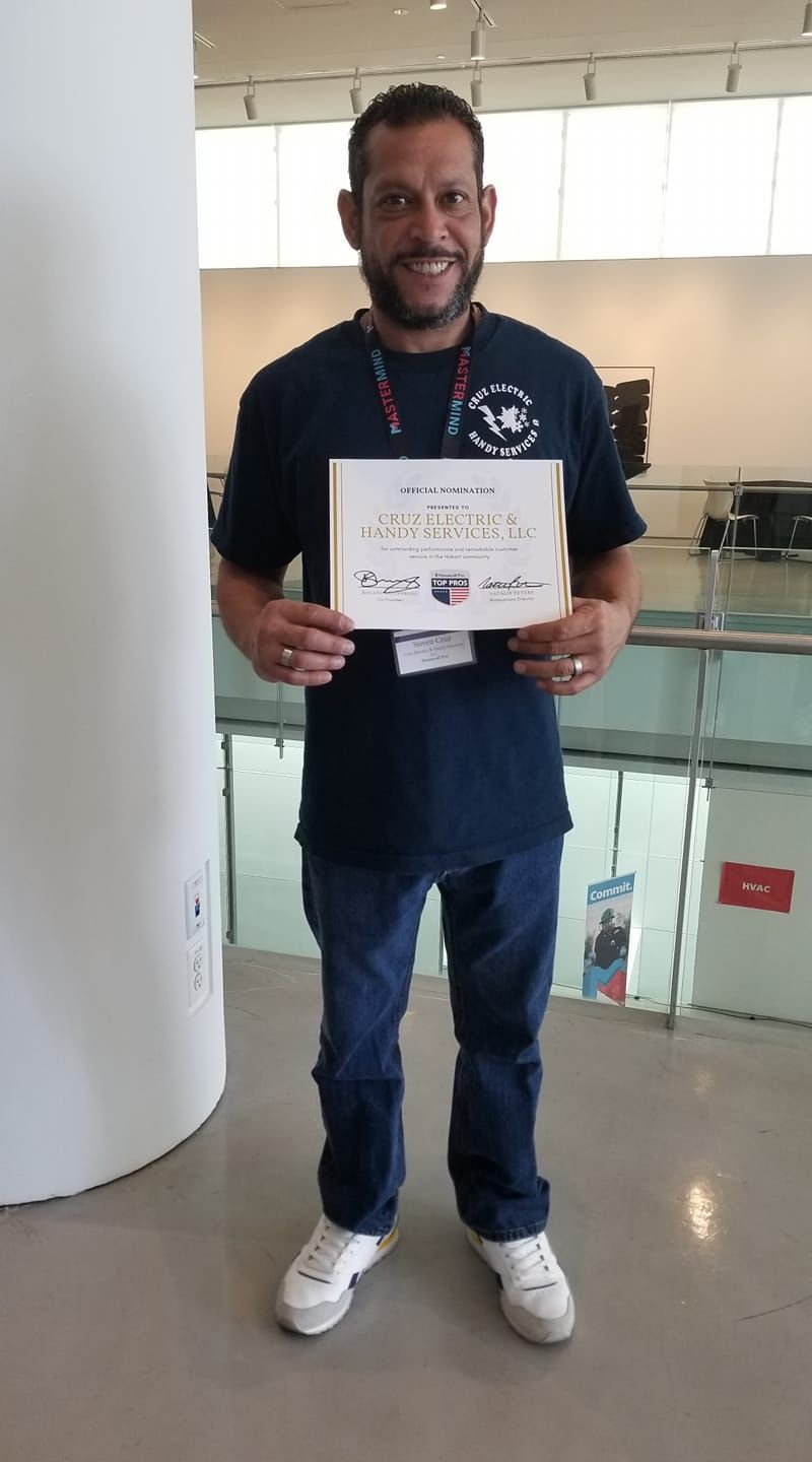 A man in a blue shirt is holding a sign in his hands.