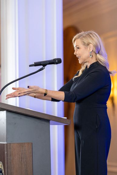 Sandra Peebles speaking at a podium, gesturing with hands. 