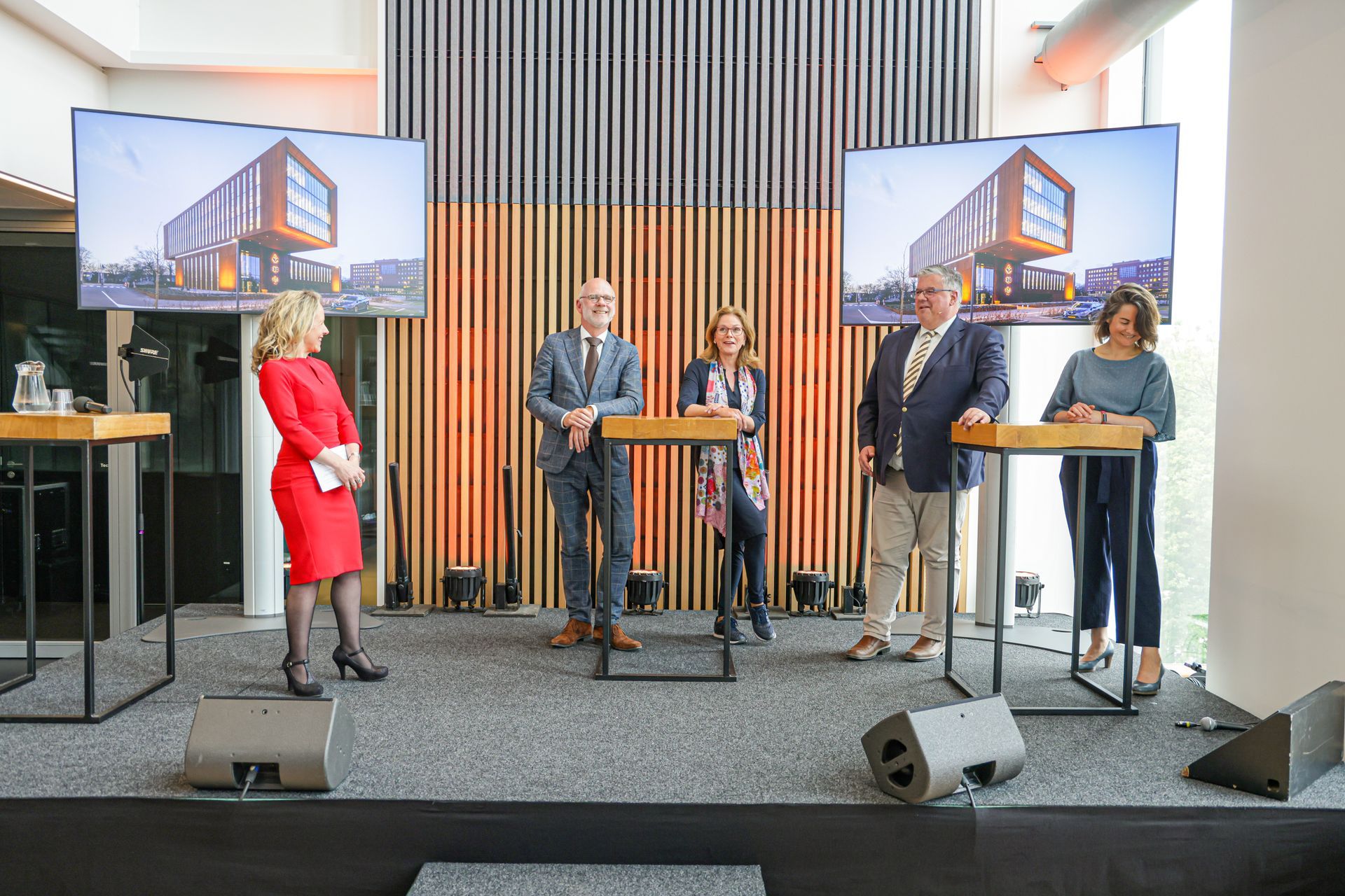 Sprekers op het podium tijdens het inhoudelijke programma van de opening van de meldkamer Oost-Nederland, begeleid door dagvoorzitter Wendelien Wouters en georganiseerd door Plan X Events.