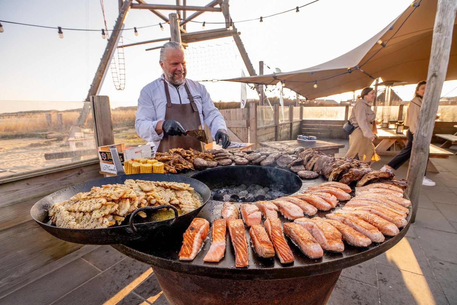 Kok bereidt barbecue tijdens het 30-jarig jubileum van Gevel Design Beek, volledig verzorgd door Plan X Events.