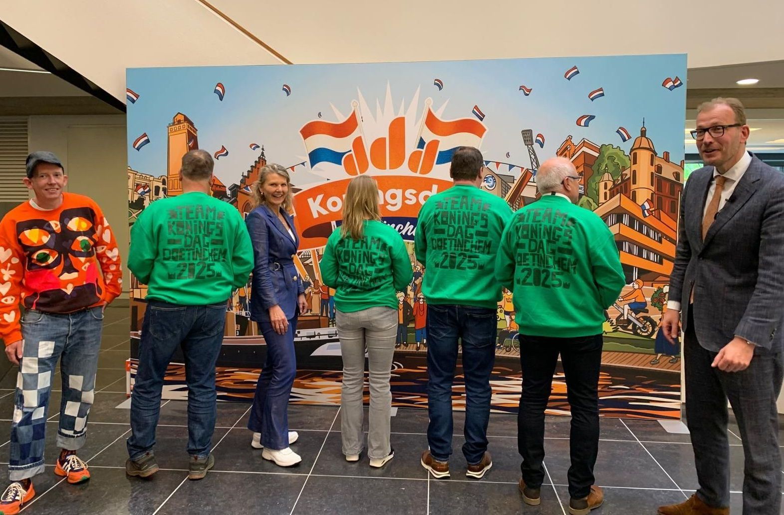Burgemeester Bouman onthult de groene Koningsdag-vrijwilligerstruien in Doetinchem, georganiseerd en ondersteund door Plan X Events.