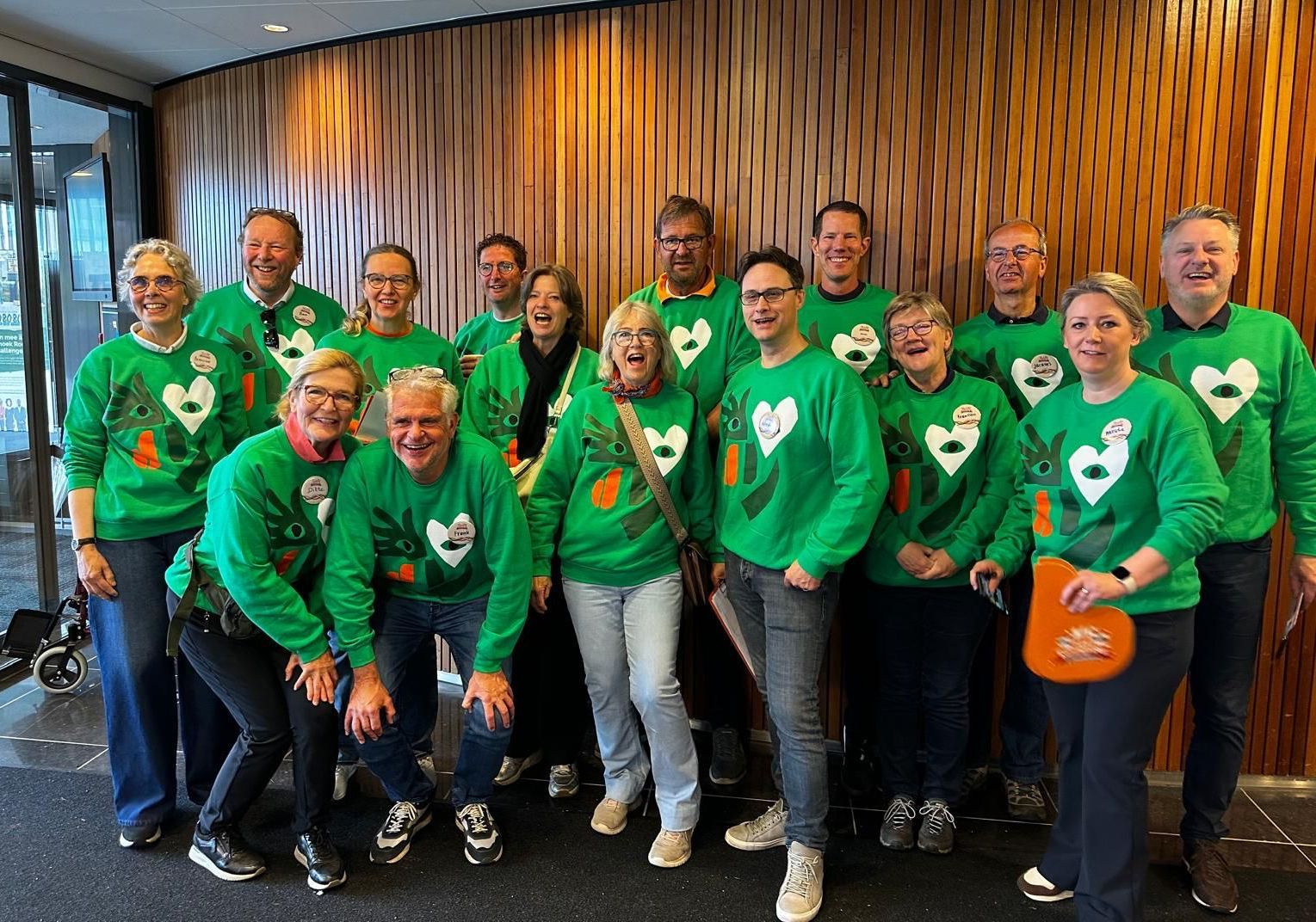 Vrijwilligers van Koningsdag in Doetinchem lachen en dragen hun groene truien, professioneel begeleid door Plan X Events.