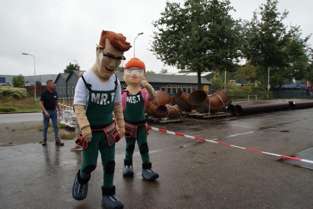 Twee mascottes in opvallende overalls tijdens de Open Bedrijvendag Doetinchem, die bezoekers verwelkomen en bijdragen aan de feestelijke sfeer, georganiseerd door Plan X Events.