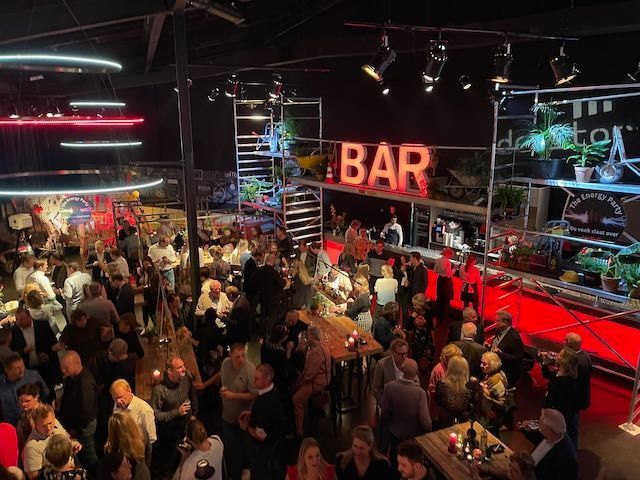 Grote menigte gasten bij de bar tijdens het relatie- en personeelsevent ‘De vonk slaat over’ van WBC Bouwgroep in Theater de Storm, georganiseerd en geproduceerd door Plan X Events.